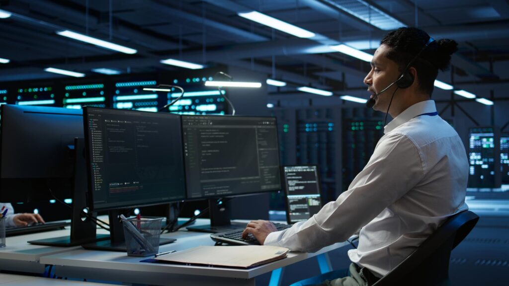 employee working in a server room with headphones on